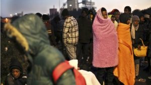 Migrants wait for busses